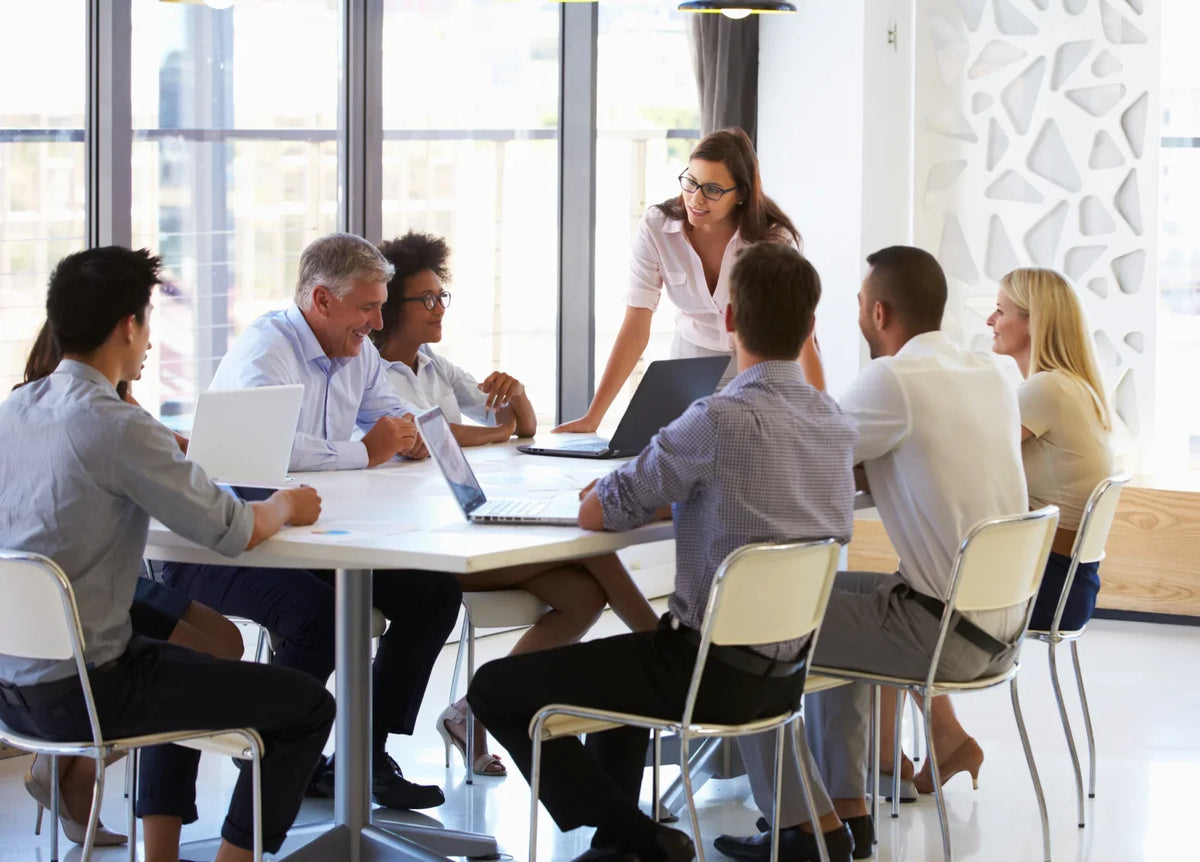Diverse professional team in a meeting room during a collaborative business coaching session.