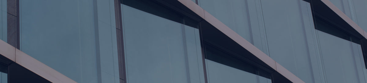 Modern glass facade of a corporate office building with reflective windows.